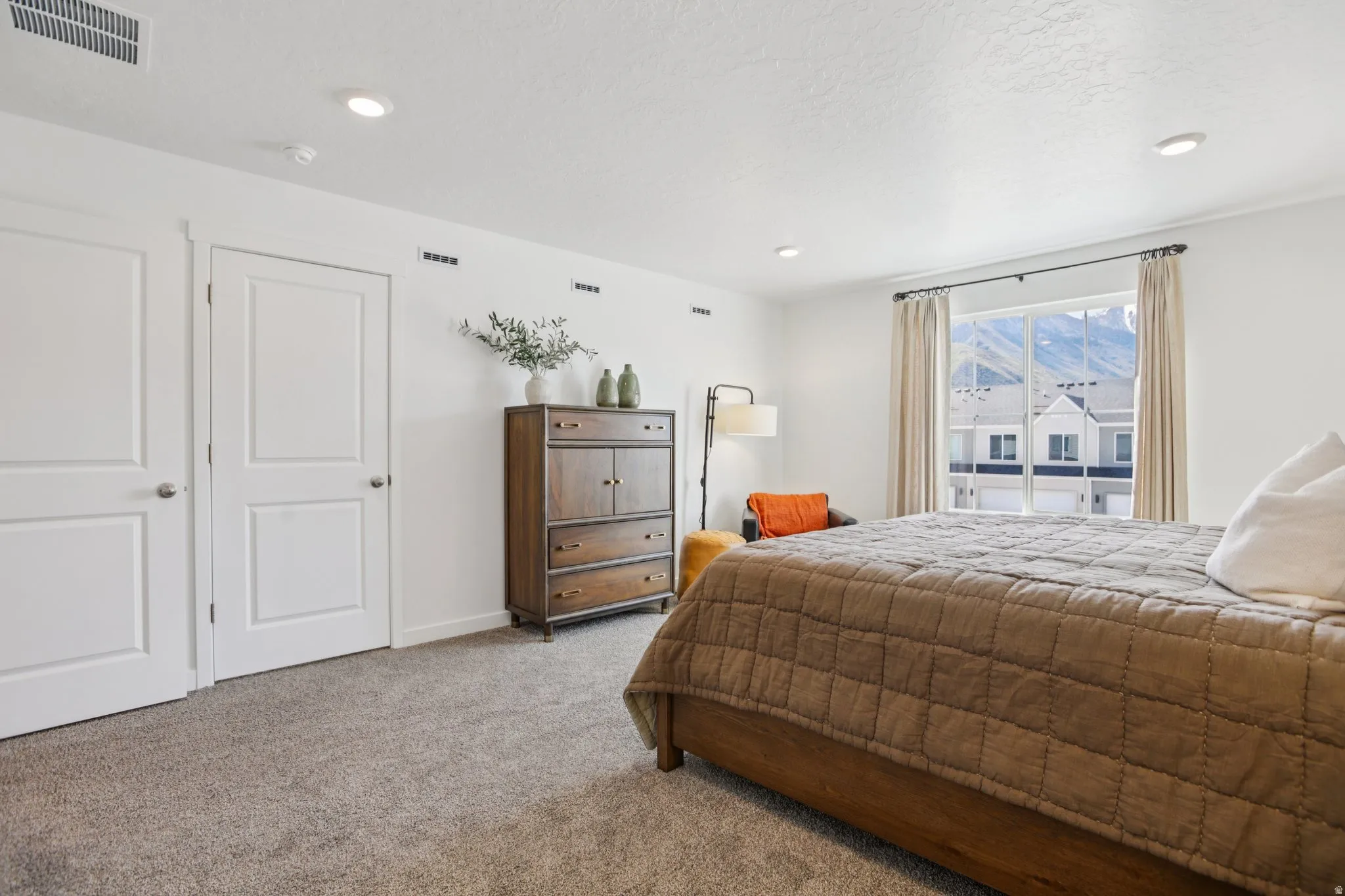 Wall-to-wall carpeting, recessed ceiling lighting, two panel doors, and a large window with mountain scenery