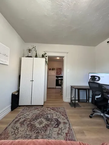 Wood-finish flooring throughout, white baseboards, and a framed doorway