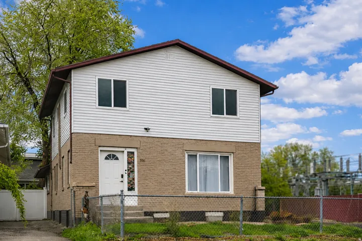 Two-story residence featuring a brick first level and horizontal siding on the second level