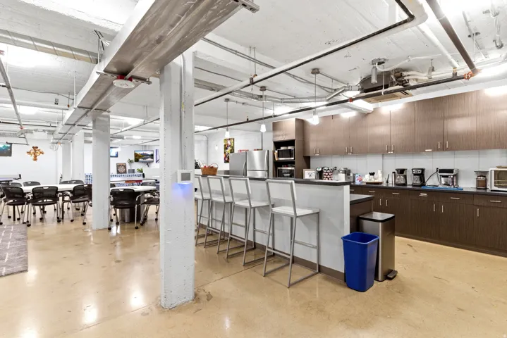 Contemporary kitchen area with stainless steel appliances, extensive cabinetry, and a breakfast bar