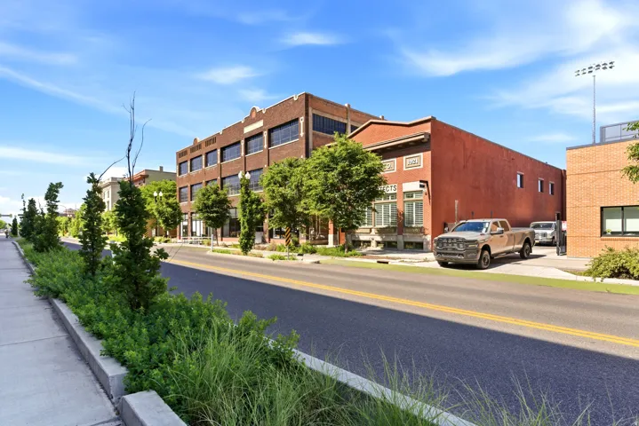 Brick commercial building with large windows and a decorative cornice