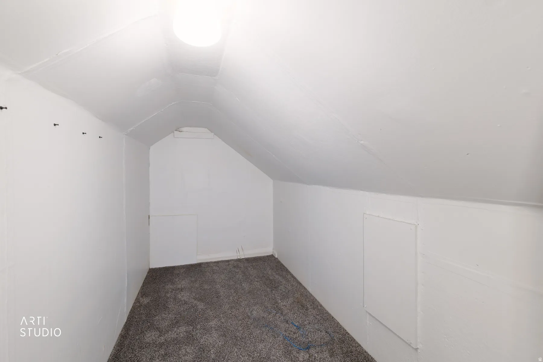 Carpeted flooring with sloped ceilings and a flush-mount ceiling light