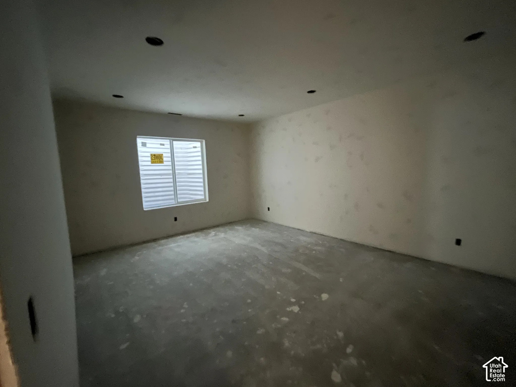 Unfinished interior space with an egress window and recessed ceiling lighting