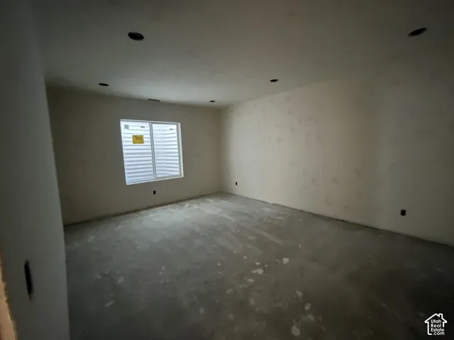 Unfinished interior space with an egress window and recessed ceiling lighting