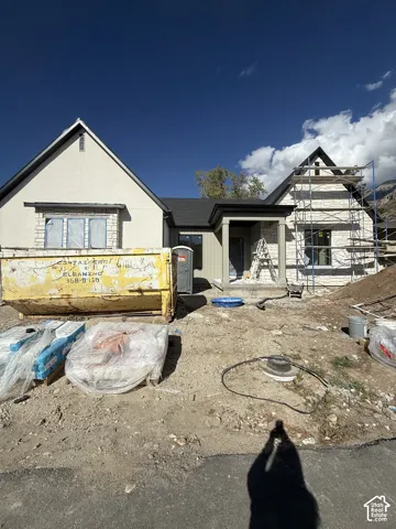 Exterior facade featuring a combination of stucco and stone masonry, steeply pitched rooflines, and a covered entry porch