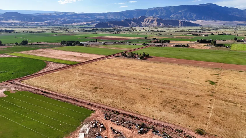 Expansive rural landscape featuring diverse agricultural fields and distant mountain ranges