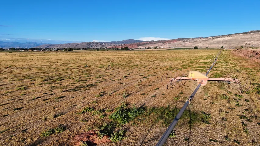 Expansive open land featuring an irrigation system and distant mountain ranges