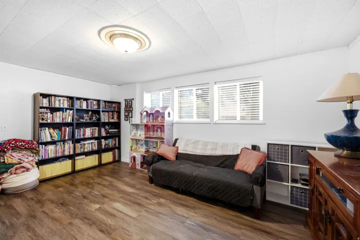 Recessed ceiling light fixture, wood-finish flooring, and multiple windows with blinds