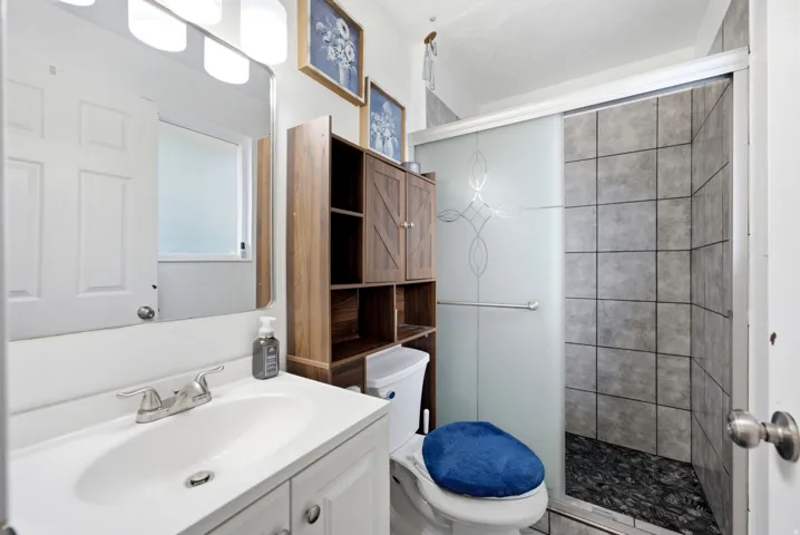 Vanity with an integrated sink, brushed nickel faucet, large mirror, and three-light fixture