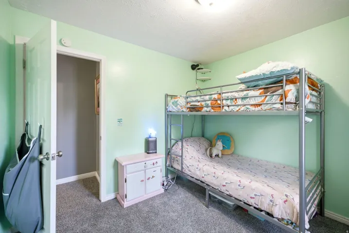Carpeted room with light green walls and a white paneled door
