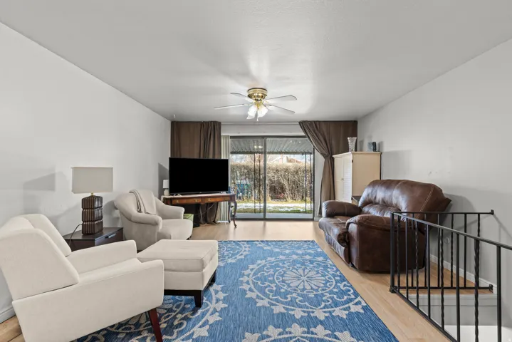 Light wood-finish flooring with white walls and a ceiling fan