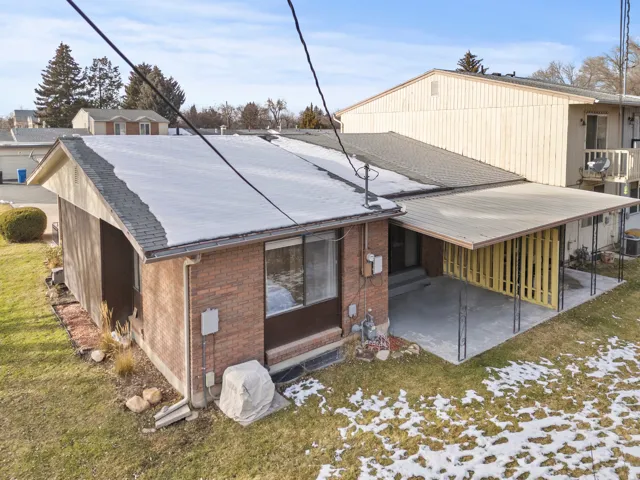 Brick exterior with a covered patio featuring a metal roof and decorative vertical slat screen