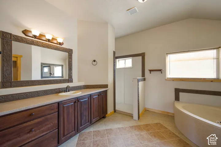 Double vanity with an integrated sink, framed mirror, and warm wood-finish cabinetry