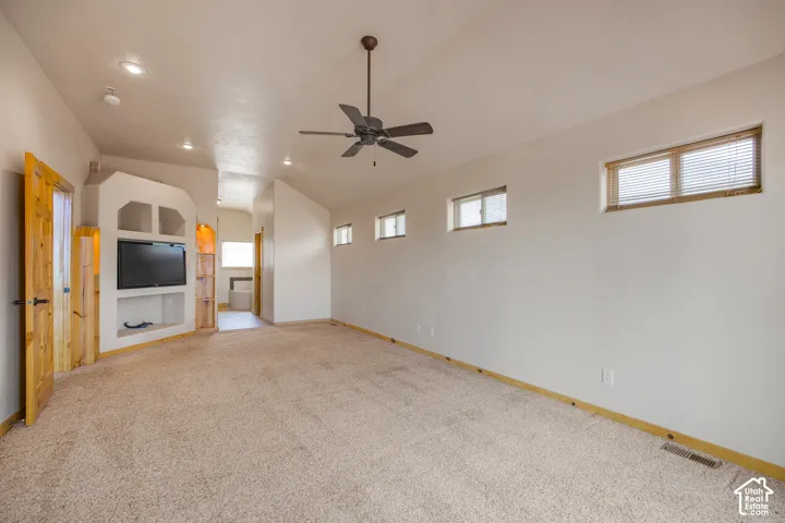 Built-in entertainment niche, recessed lighting, and ceiling fan