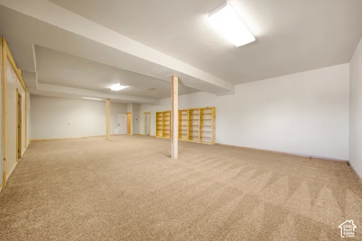 Expansive carpeted area with built-in shelving and recessed lighting