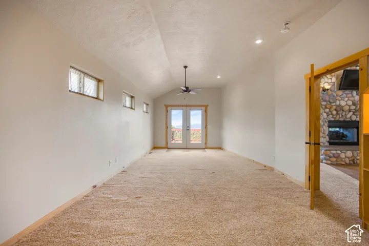 Vaulted ceiling with a ceiling fan, recessed lighting, and wood-trim French doors