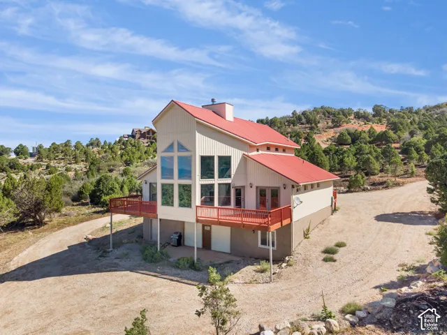 Contemporary exterior with a red metal roof, a full-length deck, and extensive fenestration