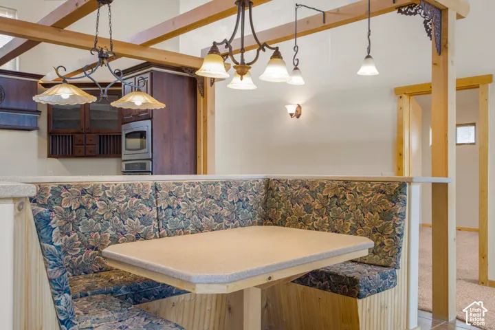 Built-in banquette seating with a patterned fabric, integrated dining table, and wood paneling