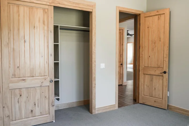 Carpeted flooring with light wood-finish trim and doors
