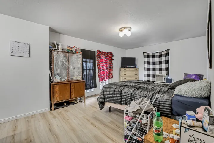 Wood-finish flooring with white walls and a ceiling-mounted light fixture