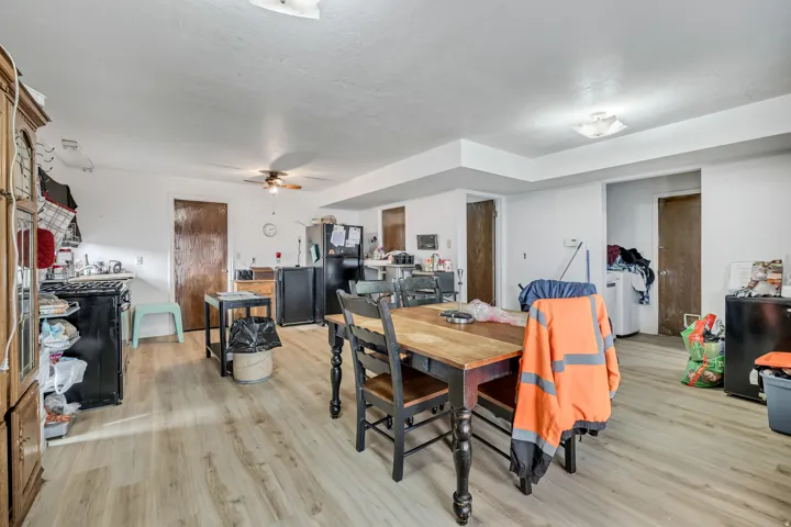 Wood-finish flooring throughout, featuring recessed ceiling details and ceiling fan