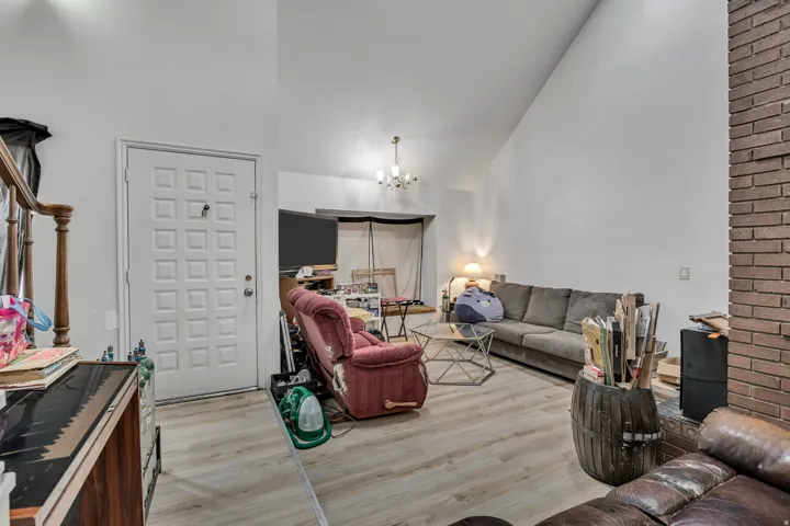 Vaulted ceilings, wood-finish flooring, brick fireplace, and a paneled entry door