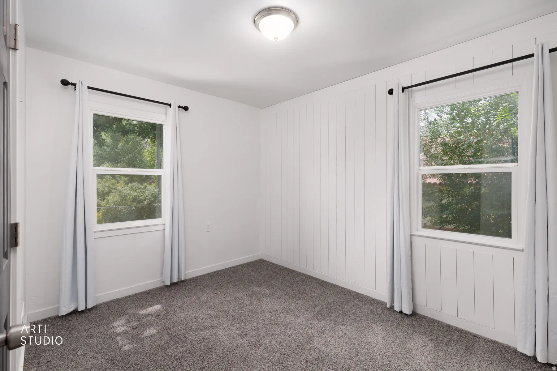 Wall-to-wall carpeting and white walls with a board and batten accent