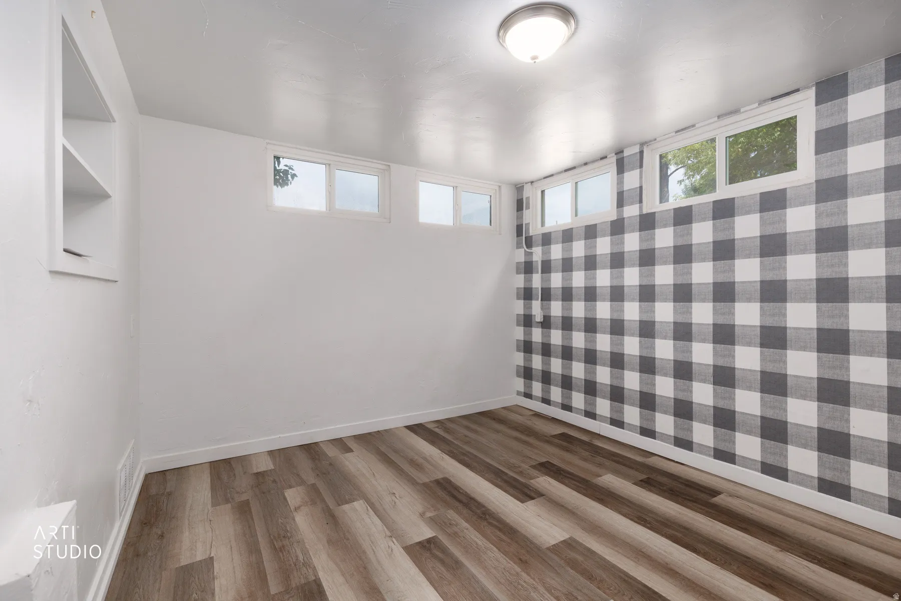 Wood-finish flooring, built-in shelving, white trim, recessed windows, and flush-mount ceiling lighting