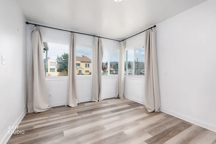 Wood-finish flooring throughout, complemented by white walls and multiple windows