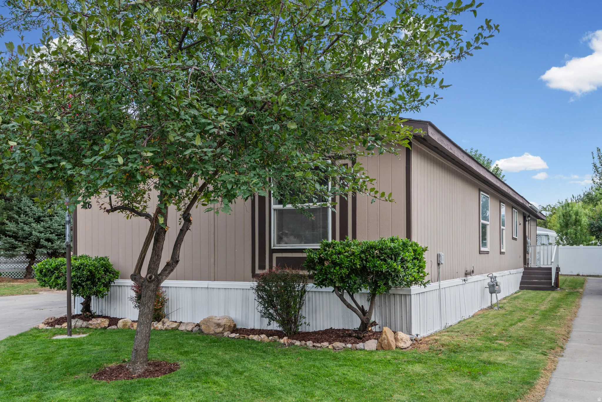 Siding exterior with contrasting trim, white skirting, and a sloped roof