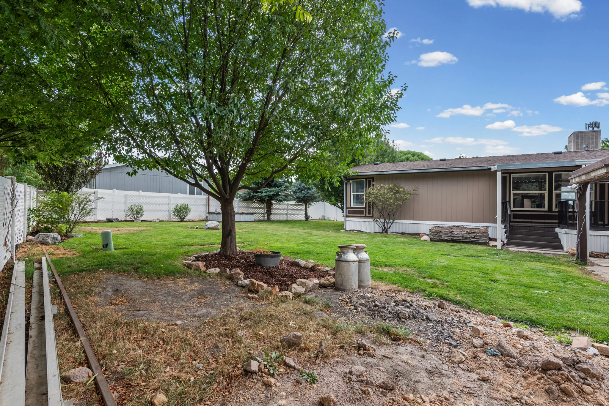 Expansive lawn area with mature trees and perimeter fencing