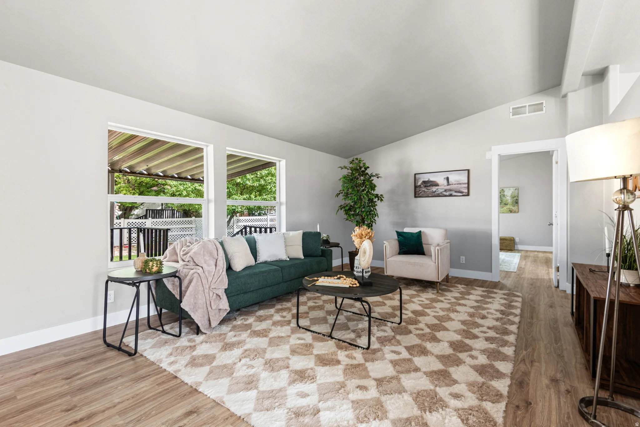 Vaulted ceiling with exposed beam, wood-finish flooring, recessed lighting, and multiple windows