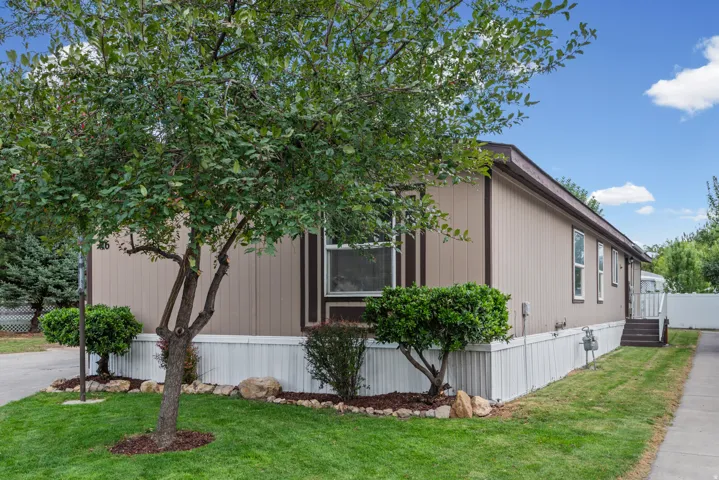 Siding exterior with contrasting trim, white skirting, and a sloped roof