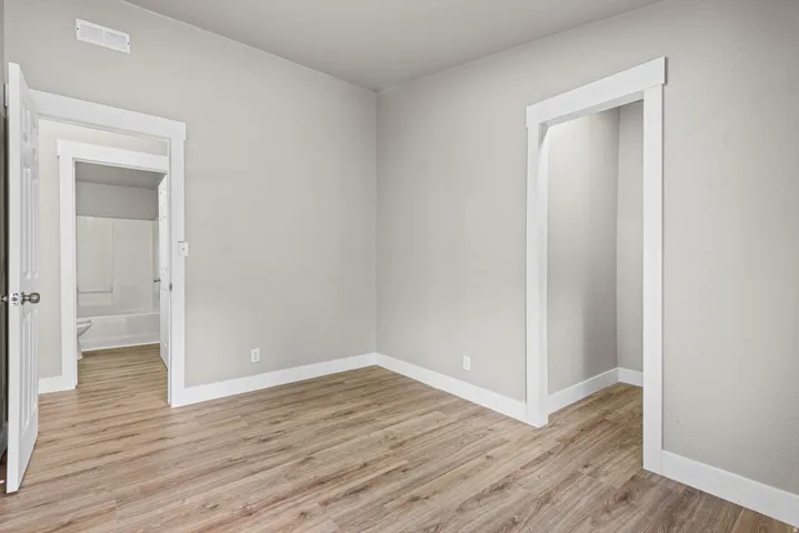 Wood-finish flooring, white baseboards, and neutral wall tones
