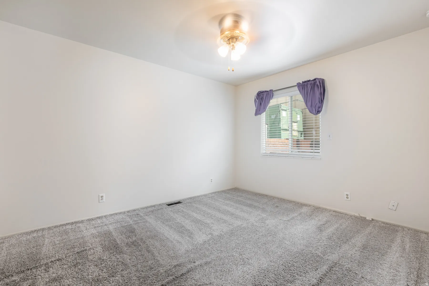 Recessed window with blinds, ceiling fan, and light-toned walls