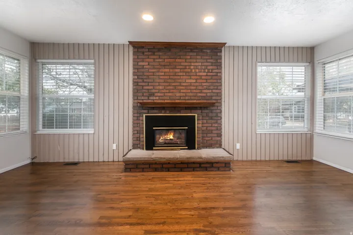 Brick fireplace with a wood mantel, raised hearth, and metal firebox