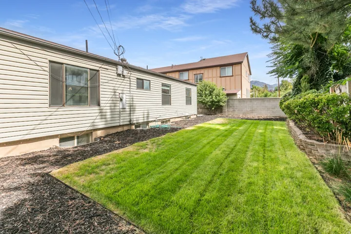 Expansive lawn area, concrete block retaining wall, and mature landscaping