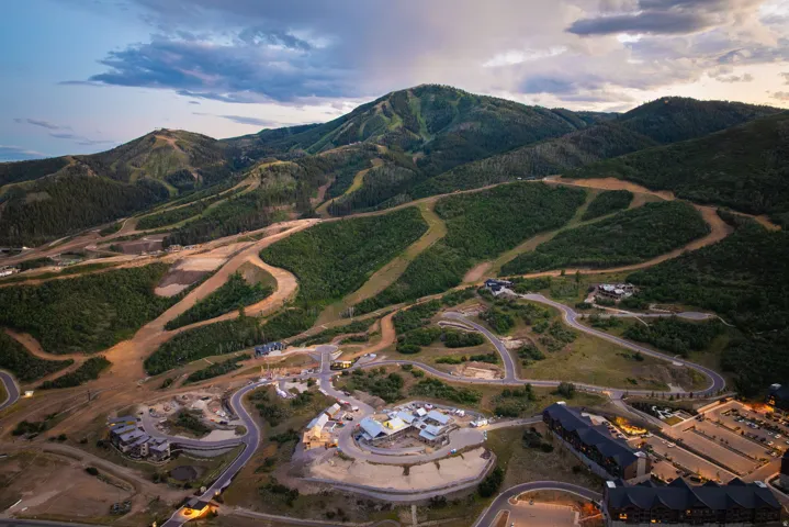 Mountainous terrain featuring developed ski runs, a paved road network, and multiple residential structures