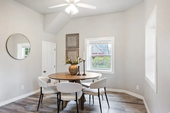Neutral wall paint, wood-finish flooring, white trim, and a ceiling fan
