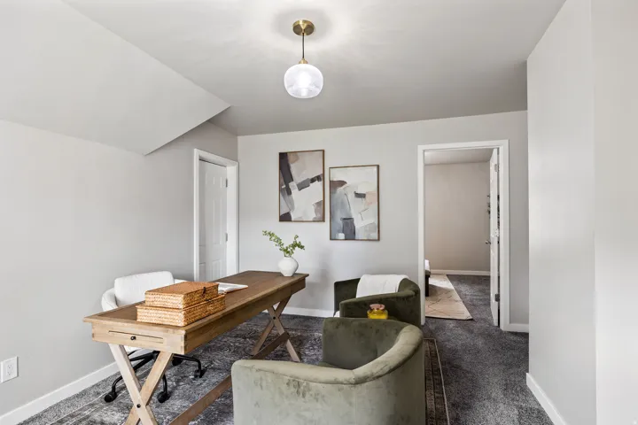 Recessed wall space, overhead globe light fixture, wood-finish desk with drawer, and light gray wall finish
