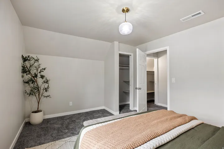 Recessed lighting, sloped ceiling, two built-in closets with shelving, neutral wall color, and plush carpet flooring