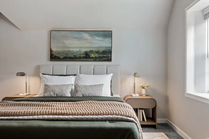 Upholstered headboard, built-in window, sloped ceiling detail, carpeted flooring, and a built-in nightstand with open shelving