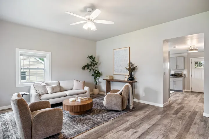 Neutral color palette, wood-finish flooring, white trim details, recessed lighting, and a ceiling fan with integrated lighting