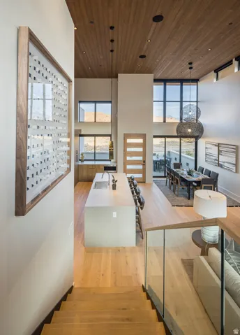 Two-story living area with wood-finish flooring, a wood-paneled ceiling, and large windows