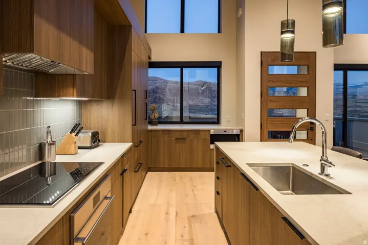 Contemporary kitchen featuring wood-finish cabinetry, light-toned countertops, and light wood-finish flooring