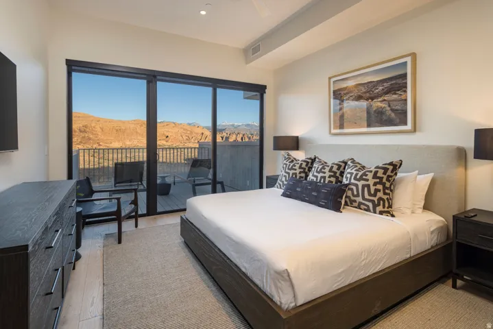 Bedroom with floor-to-ceiling sliding glass doors opening to a private balcony