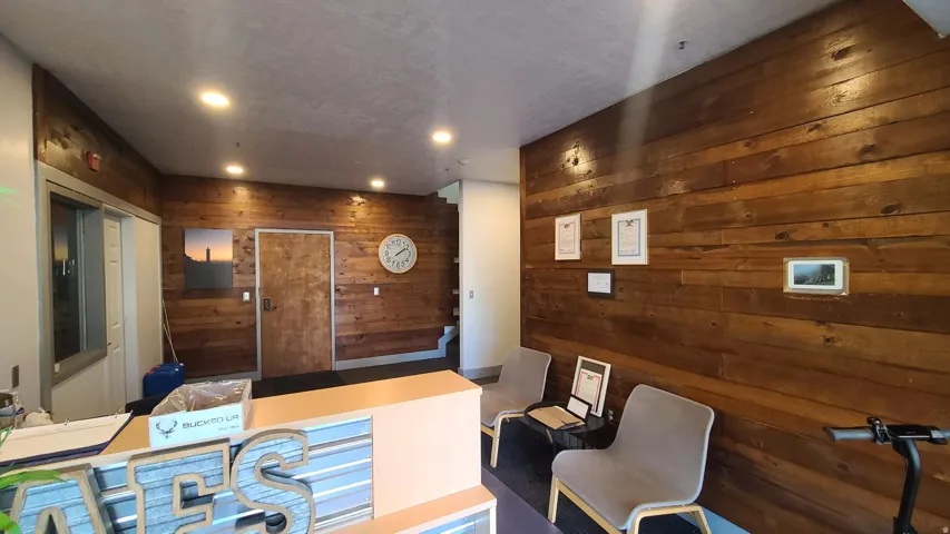 Wood-paneled accent wall, recessed ceiling lighting, and a solid wood door