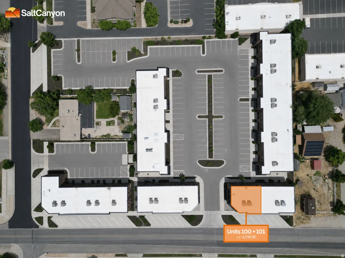 Multi-unit complex featuring multiple buildings, extensive surface parking, and street frontage