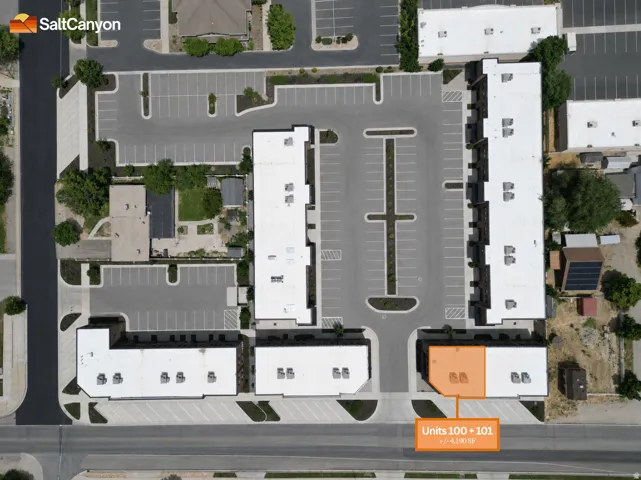 Multi-unit complex featuring multiple buildings, extensive surface parking, and street frontage