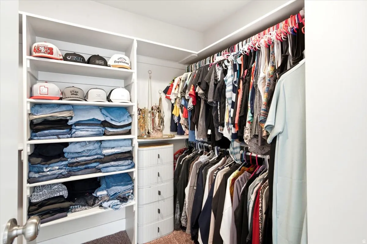 Built-in closet shelving and multiple hanging rods provide ample storage